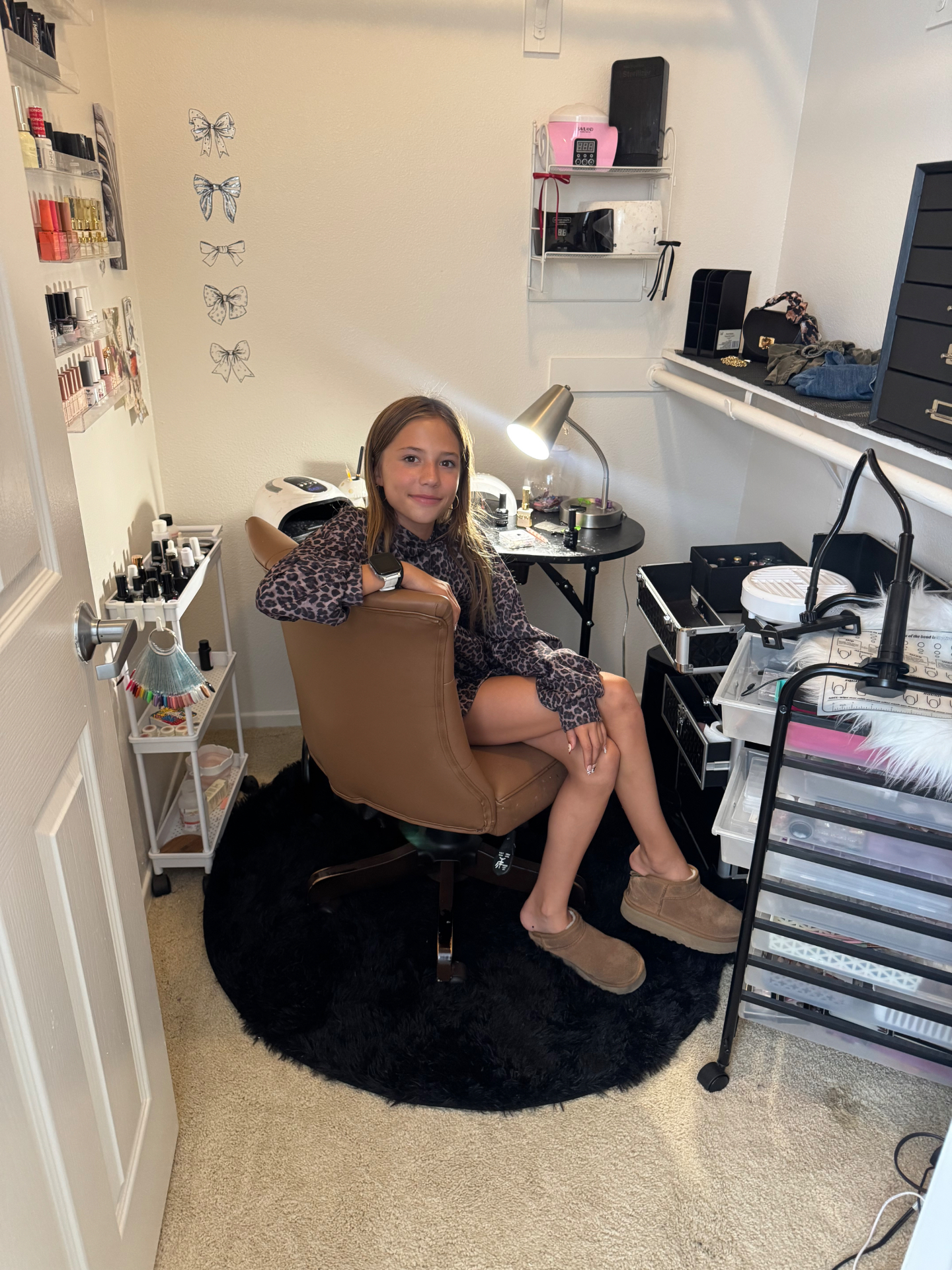 Jordan sitting in her closet nail studio surrounded by polishes, lamps and supplies